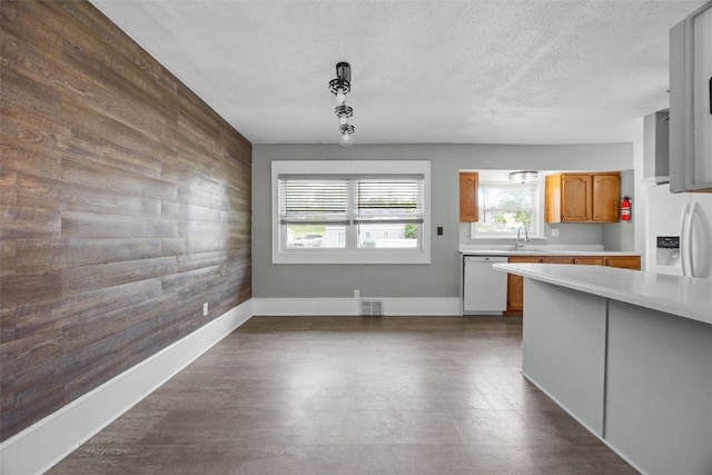 2220 D St SW, Cedar Rapids, IA 52404 - kitchen featuring white appliances, light countertops, an accent wall, hanging light fixtures, and a textured ceiling