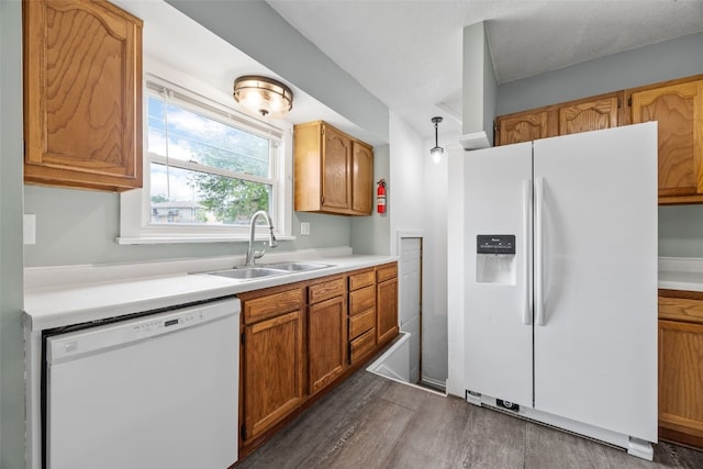 2220 D St SW, Cedar Rapids, IA 52404 - kitchen with white appliances, a sink, dark wood-type flooring, light countertops, and brown cabinets