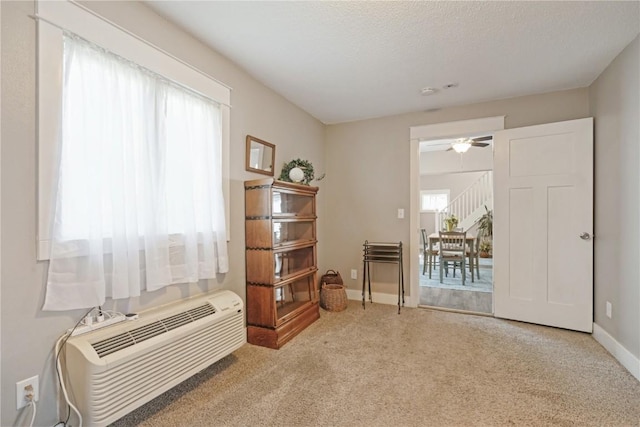 407 7th Ave SW, Cedar Rapids, IA 52404 - sitting room featuring carpet flooring, baseboards, a ceiling fan, and a wall mounted air conditioner