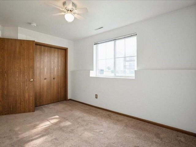 1200 Murray St NE Unit 1, Cedar Rapids, IA 52402 - unfurnished bedroom with carpet, a closet, baseboards, and a ceiling fan