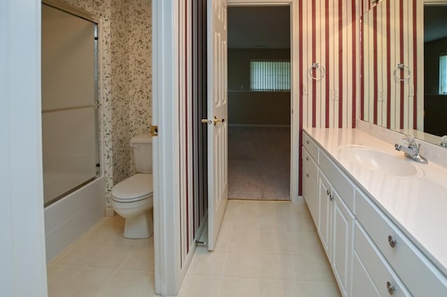 3730 Deer Valley Dr Unit B, Marion, IA 52302 - bathroom with wallpapered walls, vanity, toilet, tile patterned floors, and bath / shower combo with glass door