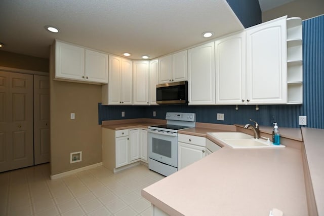 3730 Deer Valley Dr Unit B, Marion, IA 52302 - kitchen with white range with electric stovetop, stainless steel microwave, a sink, open shelves, and a peninsula
