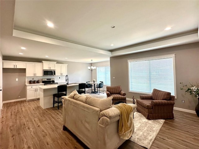 914 Juneberry Dr, Palo, IA 52324 - living area with a raised ceiling, a chandelier, wood finished floors, baseboards, and recessed lighting