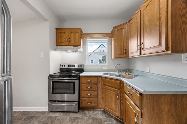 1814 9th St SW, Cedar Rapids, IA 52404 - kitchen with appliances with stainless steel finishes, under cabinet range hood, a sink, brown cabinets, and light countertops