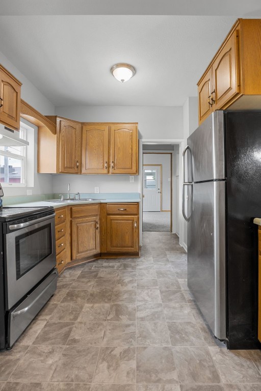 1814 9th St SW, Cedar Rapids, IA 52404 - kitchen with appliances with stainless steel finishes, healthy amount of natural light, under cabinet range hood, and light countertops