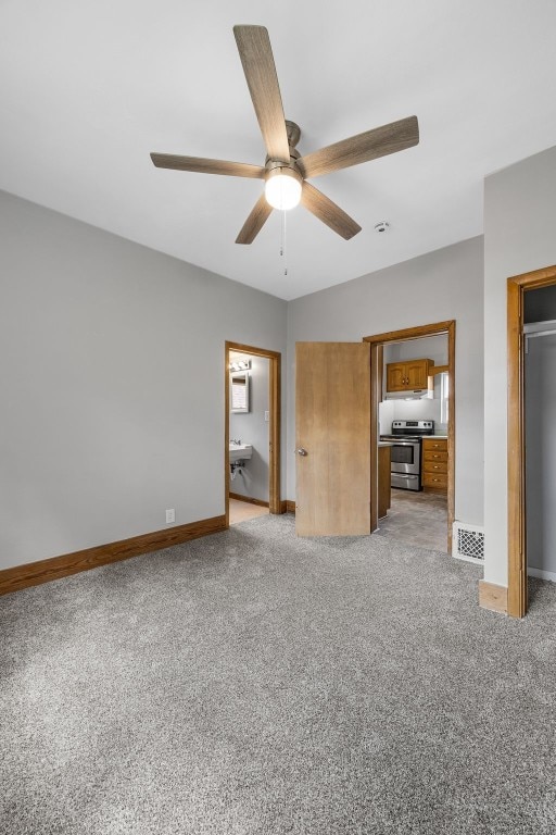 1814 9th St SW, Cedar Rapids, IA 52404 - unfurnished bedroom with light carpet, baseboards, ensuite bath, and a ceiling fan