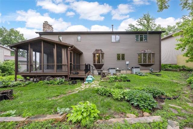 4633 Northwood Dr NE, Cedar Rapids, IA 52402 - rear view of house featuring a sunroom, a chimney, central air condition unit, and a lawn