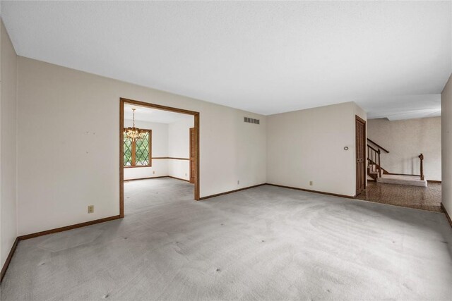 4633 Northwood Dr NE, Cedar Rapids, IA 52402 - spare room with stairway, a chandelier, baseboards, and carpet