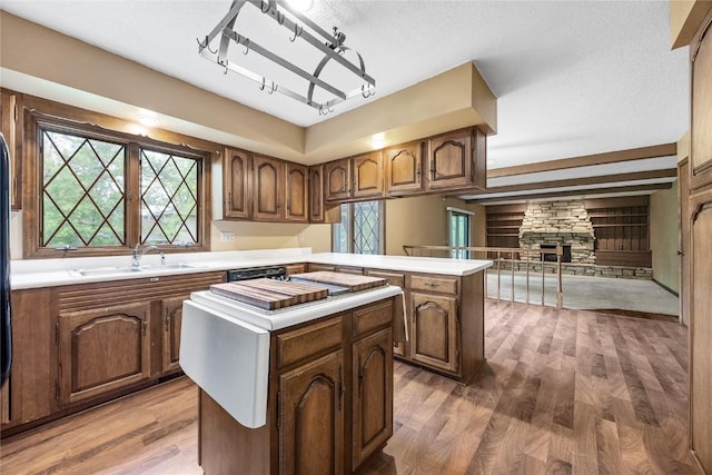 4633 Northwood Dr NE, Cedar Rapids, IA 52402 - kitchen featuring a sink, a kitchen island, wood finished floors, a peninsula, and a fireplace
