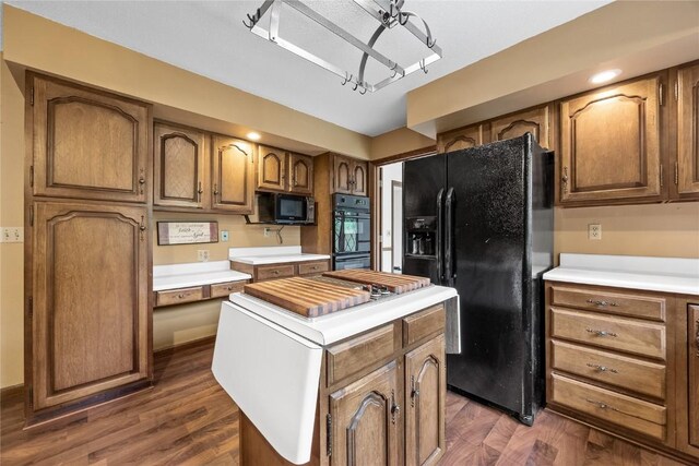 4633 Northwood Dr NE, Cedar Rapids, IA 52402 - kitchen featuring black appliances, a kitchen island, light countertops, and dark wood finished floors