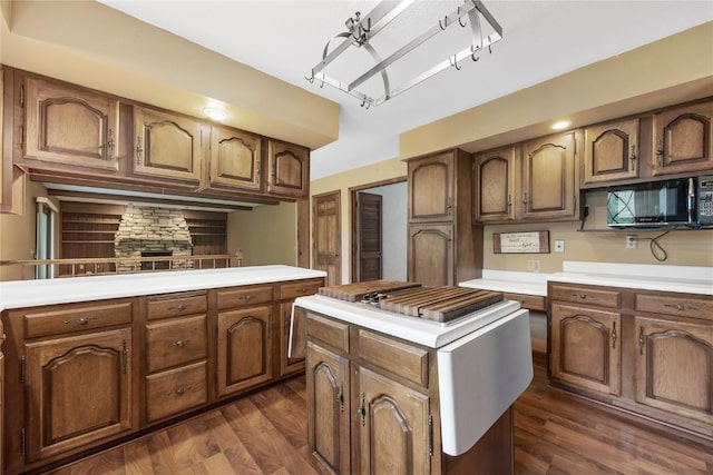 4633 Northwood Dr NE, Cedar Rapids, IA 52402 - kitchen featuring light countertops, dark wood-style flooring, a kitchen island, and black microwave
