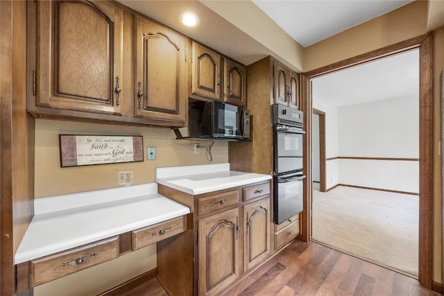 4633 Northwood Dr NE, Cedar Rapids, IA 52402 - kitchen with black appliances, light countertops, brown cabinets, and dark wood finished floors