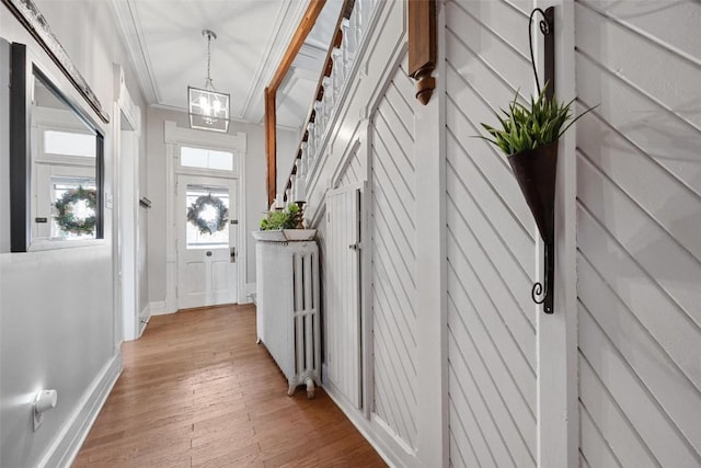 320 E St, Tipton, IA 52772 - corridor featuring baseboards, light wood-style floors, a chandelier, and ornamental molding