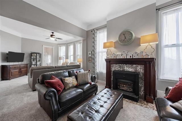 320 E St, Tipton, IA 52772 - living room featuring light carpet, plenty of natural light, a fireplace, and ceiling fan
