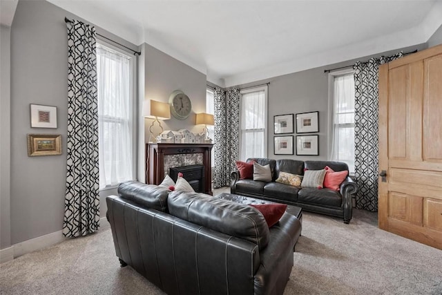 320 E St, Tipton, IA 52772 - carpeted living room featuring healthy amount of natural light, baseboards, and a fireplace