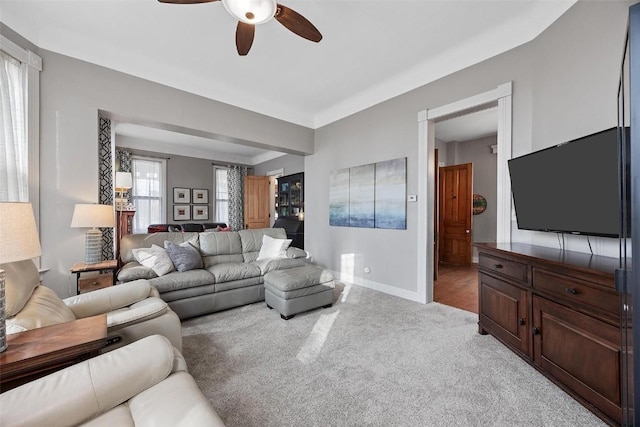 320 E St, Tipton, IA 52772 - living room featuring a ceiling fan, light carpet, and baseboards