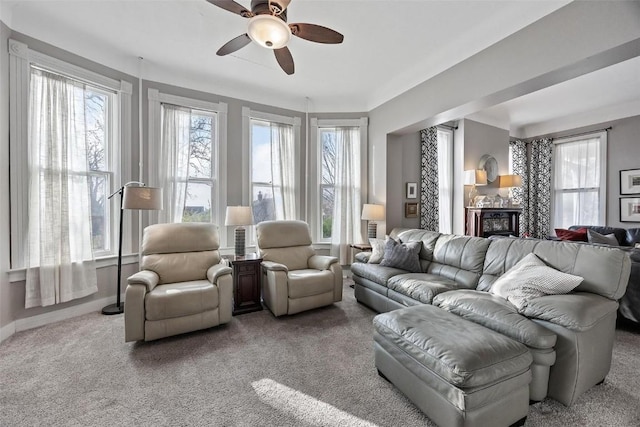 320 E St, Tipton, IA 52772 - carpeted living area featuring a ceiling fan, a glass covered fireplace, and baseboards