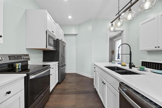 320 E St, Tipton, IA 52772 - kitchen with stainless steel appliances, a sink, light countertops, dark wood-style flooring, and recessed lighting