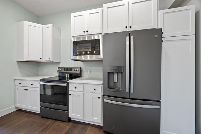 320 E St, Tipton, IA 52772 - kitchen featuring stainless steel appliances, dark wood-style floors, light countertops, white cabinetry, and baseboards