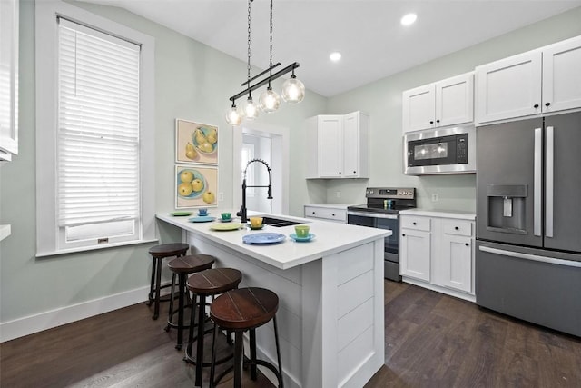 320 E St, Tipton, IA 52772 - kitchen with stainless steel appliances, a sink, a kitchen breakfast bar, white cabinets, and recessed lighting
