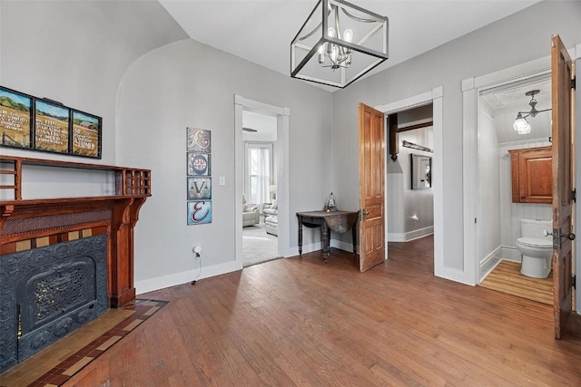 320 E St, Tipton, IA 52772 - living area featuring wood finished floors, baseboards, and a chandelier