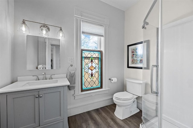 320 E St, Tipton, IA 52772 - bathroom with toilet, an enclosed shower, vanity, wood finished floors, and baseboards