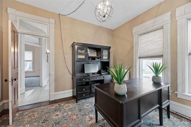 320 E St, Tipton, IA 52772 - home office featuring a chandelier, baseboards, and wood finished floors