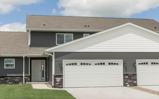 3806 English Glen Ave, Marion, IA 52302 - view of front facade featuring concrete driveway, roof with shingles, and stone siding
