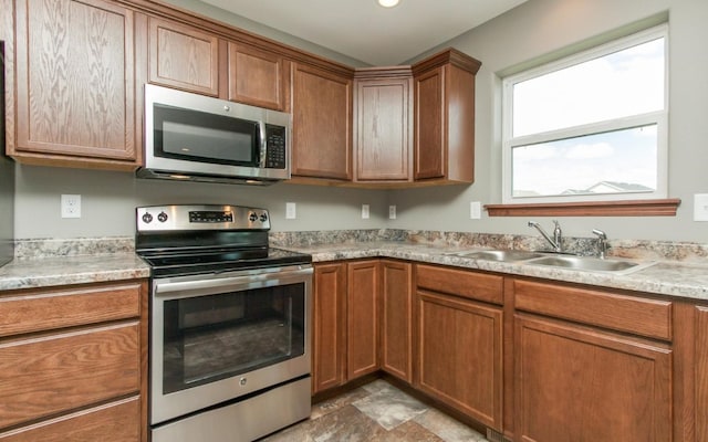 3806 English Glen Ave, Marion, IA 52302 - kitchen with stainless steel appliances, a sink, brown cabinetry, and light countertops