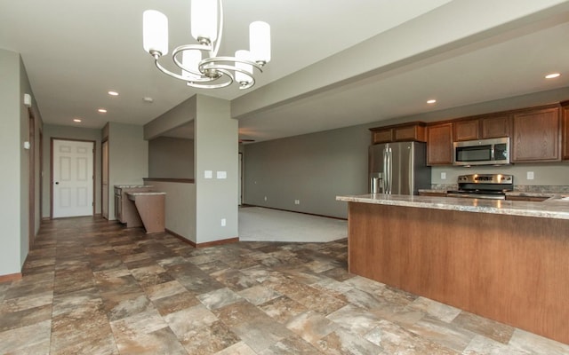 3806 English Glen Ave, Marion, IA 52302 - kitchen featuring stainless steel appliances, light stone counters, baseboards, brown cabinets, and a chandelier