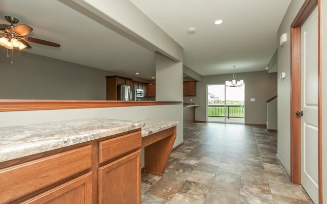 3806 English Glen Ave, Marion, IA 52302 - kitchen with appliances with stainless steel finishes, a chandelier, stone finish floors, a ceiling fan, and light countertops