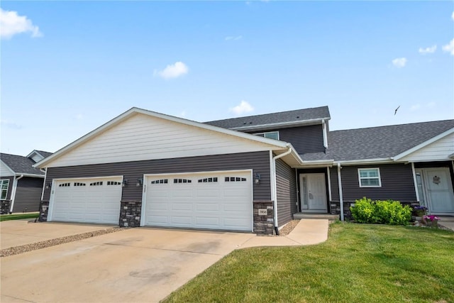 3806 English Glen Ave, Marion, IA 52302 - view of front of home with stone siding, a front lawn, concrete driveway, a garage, and a shingled roof