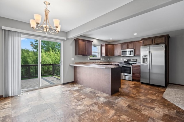 3806 English Glen Ave, Marion, IA 52302 - kitchen with stainless steel appliances, a chandelier, a peninsula, light countertops, and dark stone finish floors