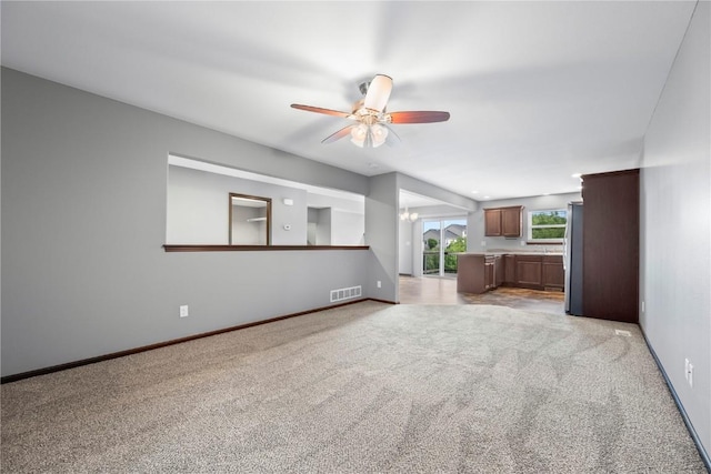 3806 English Glen Ave, Marion, IA 52302 - unfurnished living room with a ceiling fan, light colored carpet, and a chandelier