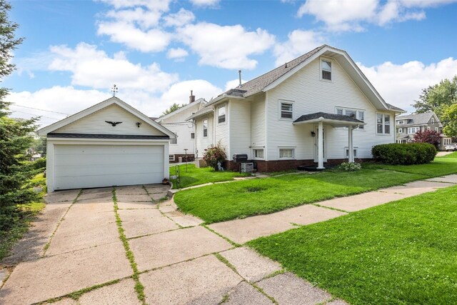2251 Bever Ave SE, Cedar Rapids, IA 52403 - view of front of house with a detached garage, a front yard, and an outdoor structure