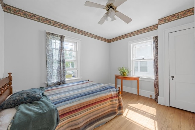 2251 Bever Ave SE, Cedar Rapids, IA 52403 - bedroom with multiple windows, light wood finished floors, baseboards, and ceiling fan