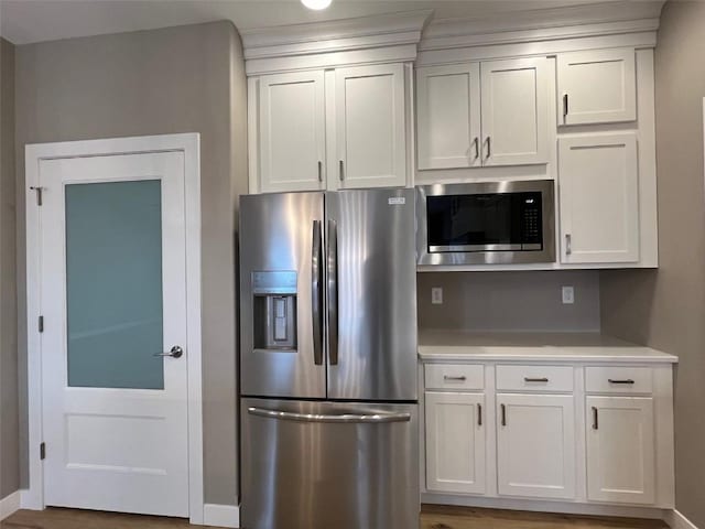 1417 Legend Dr, Tiffin, IA 52340 - kitchen with appliances with stainless steel finishes, light countertops, white cabinets, and baseboards