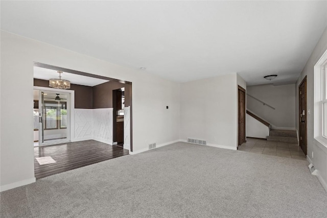 3013 Ravenwood Ter NW, Cedar Rapids, IA 52405 - unfurnished living room featuring carpet floors, stairs, a chandelier, and baseboards