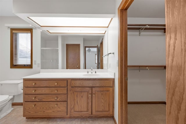 3629 Timberline Dr NE, Cedar Rapids, IA 52402 - bathroom featuring toilet, vanity, a spacious closet, and a shower with door