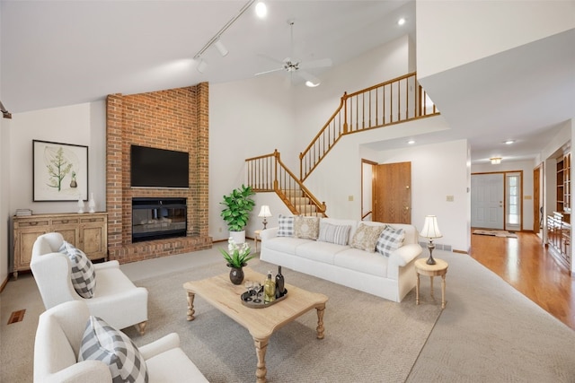 3629 Timberline Dr NE, Cedar Rapids, IA 52402 - living room with stairway, ceiling fan, a fireplace, high vaulted ceiling, and wood finished floors