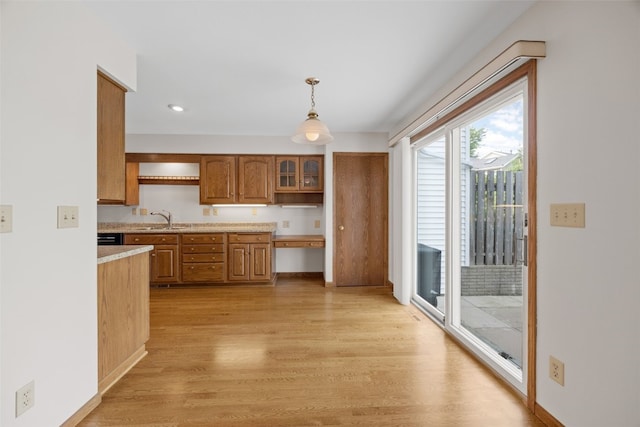 3629 Timberline Dr NE, Cedar Rapids, IA 52402 - kitchen with a sink, light countertops, light wood finished floors, brown cabinetry, and hanging light fixtures