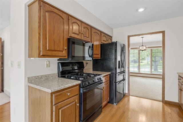 3629 Timberline Dr NE, Cedar Rapids, IA 52402 - kitchen with black appliances, light wood-style floors, light countertops, and brown cabinetry