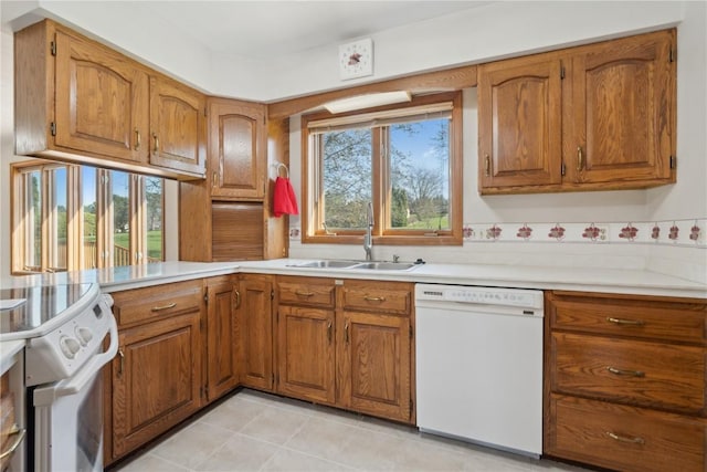 6405 Hillcrest Rd, Cedar Rapids, IA 52404 - kitchen featuring white appliances, a sink, brown cabinetry, and light countertops