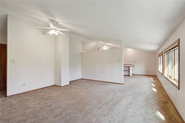 6405 Hillcrest Rd, Cedar Rapids, IA 52404 - unfurnished living room featuring a ceiling fan, light carpet, lofted ceiling, and baseboards