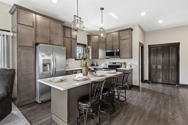 1871 Ellis Blvd NW Unit 309, Cedar Rapids, IA 52405 - kitchen featuring appliances with stainless steel finishes, a breakfast bar, dark wood-type flooring, a kitchen island, and recessed lighting