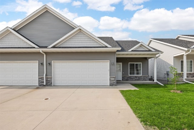 1333 Truman Ct NE Unit B, Cedar Rapids, IA 52402 - view of front of property featuring driveway, stone siding, a garage, and a front lawn