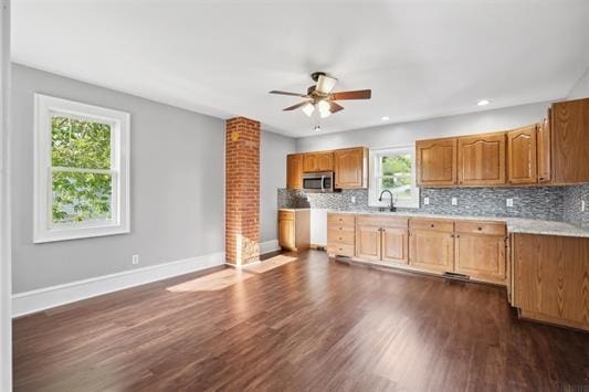 611 3rd Ave NE, Independence, IA 50644 - kitchen featuring stainless steel microwave, ceiling fan, light countertops, decorative backsplash, and recessed lighting