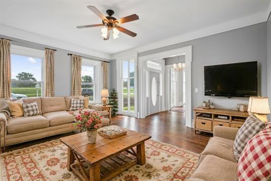 611 3rd Ave NE, Independence, IA 50644 - living room with a chandelier, wood finished floors, and a ceiling fan