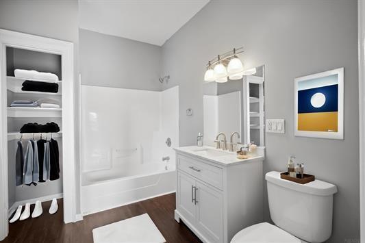 611 3rd Ave NE, Independence, IA 50644 - full bath with vanity, tub / shower combination, wood finished floors, and toilet