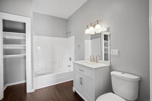 611 3rd Ave NE, Independence, IA 50644 - bathroom featuring bathing tub / shower combination, vanity, wood finished floors, and toilet